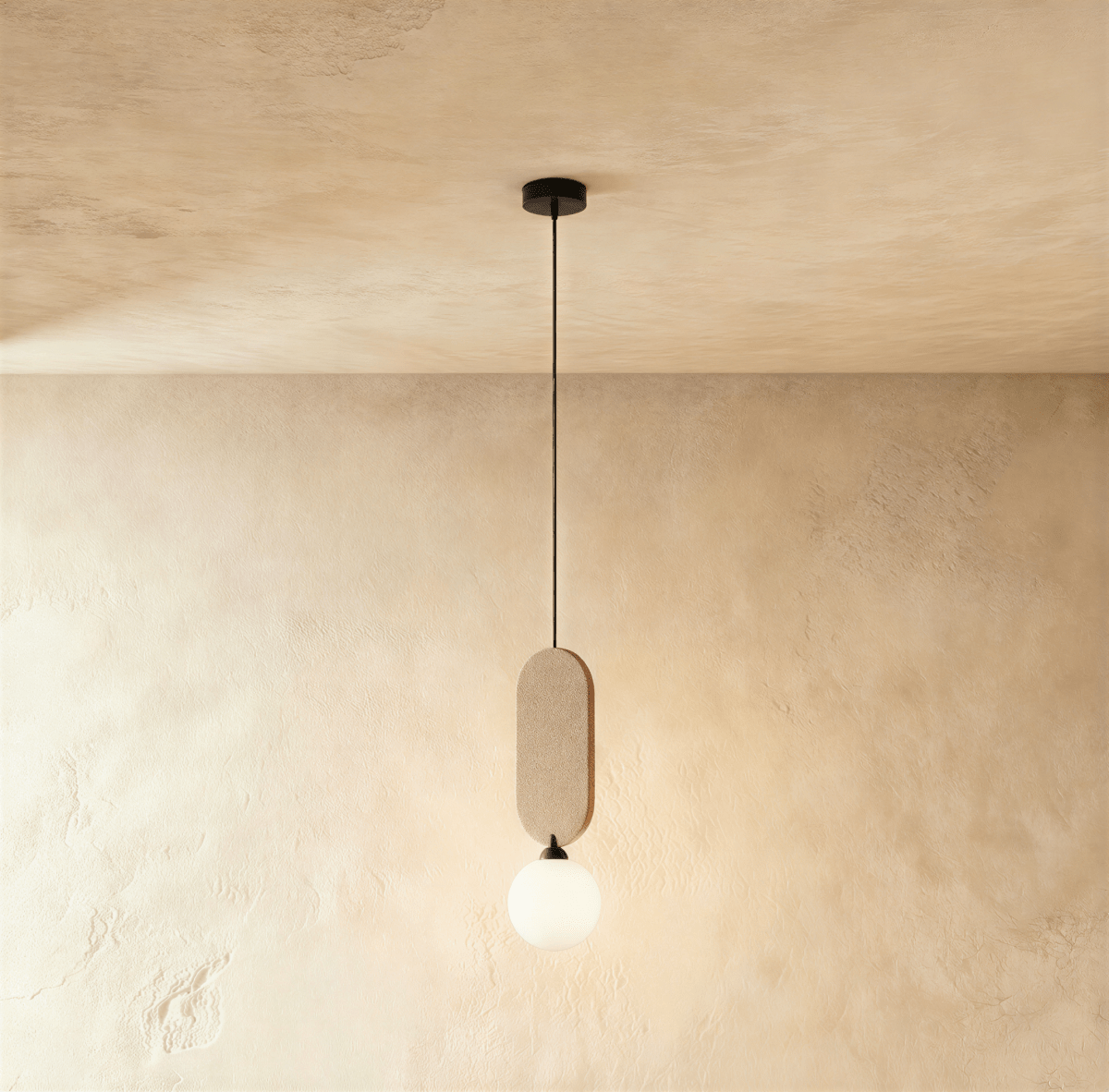 Clérachic single pendant with a sand beige fabric pill panel over a milk white glass globe, on a warm plaster wall.