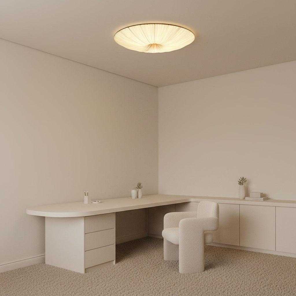 Clérachic fabric ceiling light in a pale minimalist study, above a curved white desk and a small cream armchair.