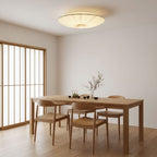 Pleated Clérachic ceiling light over a light wood dining table with four chairs, beside a sliding screen with a wooden frame.