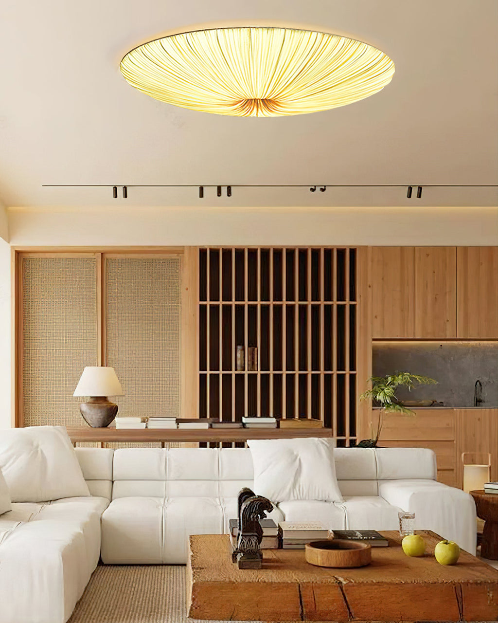 Lit Clérachic fabric ceiling light above a white modular sofa, a slatted wooden screen and a chunky timber coffee table.