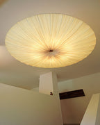 Close view from below of the pleated Clérachic ceiling light, with fine folds running from the rim into a gathered centre.