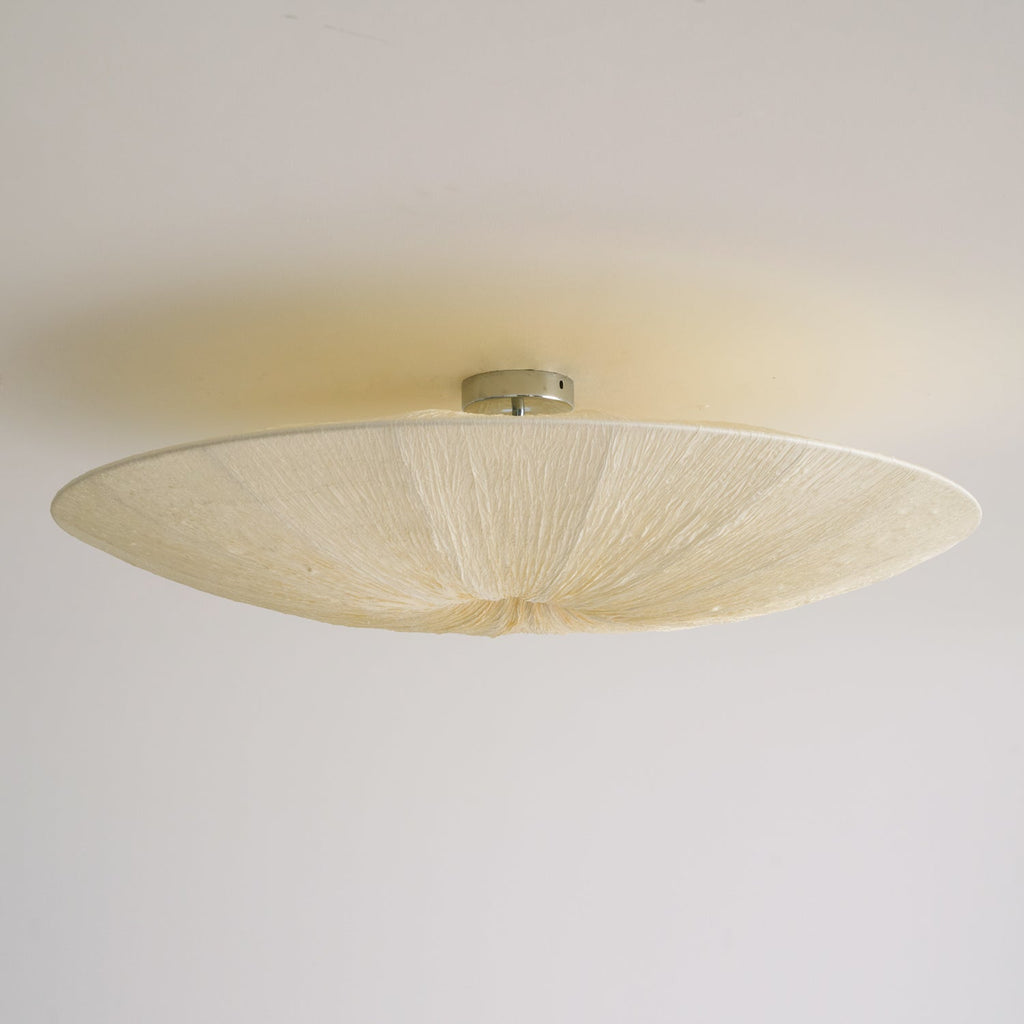 Underside of a Clérachic fabric ceiling light on a small metal canopy, with soft cream pleats and a pale ceiling.