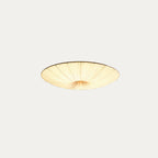 Small Clérachic pleated ceiling light on a pale grey backdrop, lit warm with a dark rim line.