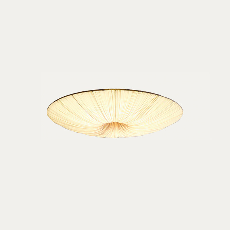 Clérachic pleated ceiling light on a pale grey backdrop, lit, shown from a lower angle with gathered folds at the centre.