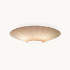 Clérachic flush-mount ceiling light with a wide, shallow pleated fabric shade in warm ivory and a round opal diffuser at the centre, on white.