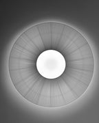 View from below of a Clérachic pleated ceiling light in grey tones, a finely pleated disc with a round white diffuser and a halo of light.