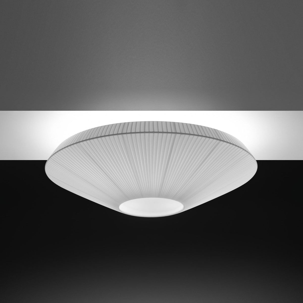 Grey-toned Clérachic pleated ceiling light with a pale opal diffuser, lit against a dark ceiling.