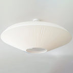 Close angled view of a white Clérachic ceiling light with a short mounting stem, and the diffuser opening at the centre.