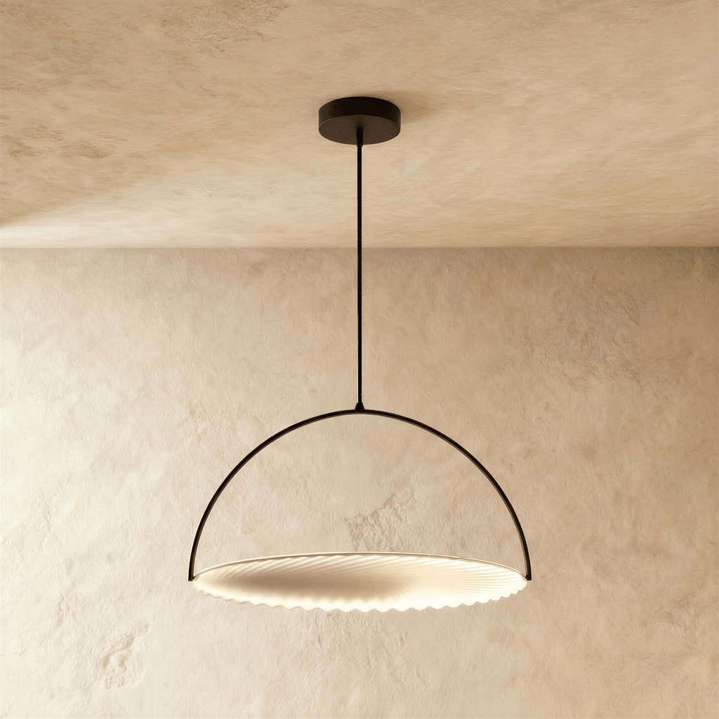 Clérachic larger black arch pendant with a wide pleated white disc, lit warmly and hanging from a ceiling rod.