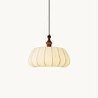Pleated cream fabric dome pendant with a walnut-colour wood top and a black bead above, hung on a thin cord, from Clérachic on white.