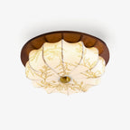 A round Clérachic ceiling light with a dark walnut rim and a scalloped off-white fabric shade, finely etched with a floral pattern.