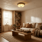 A Clérachic fabric ceiling light glows in a living room with a linen sofa, a low wooden table, shelves and a small bonsai.