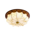 A Clérachic ceiling light with a walnut rim, a pleated floral-etched shade and a brass centre cap, on a plain white backdrop.