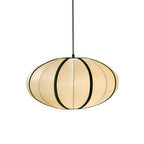 A flattened fabric pendant with black ribs and a warm glow hangs on a black cord against a white backdrop, from Clérachic.