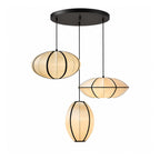 Three fabric pendants, one oval, one pointed and one egg-shaped, hang from a round black ceiling plate against white, from Clérachic.