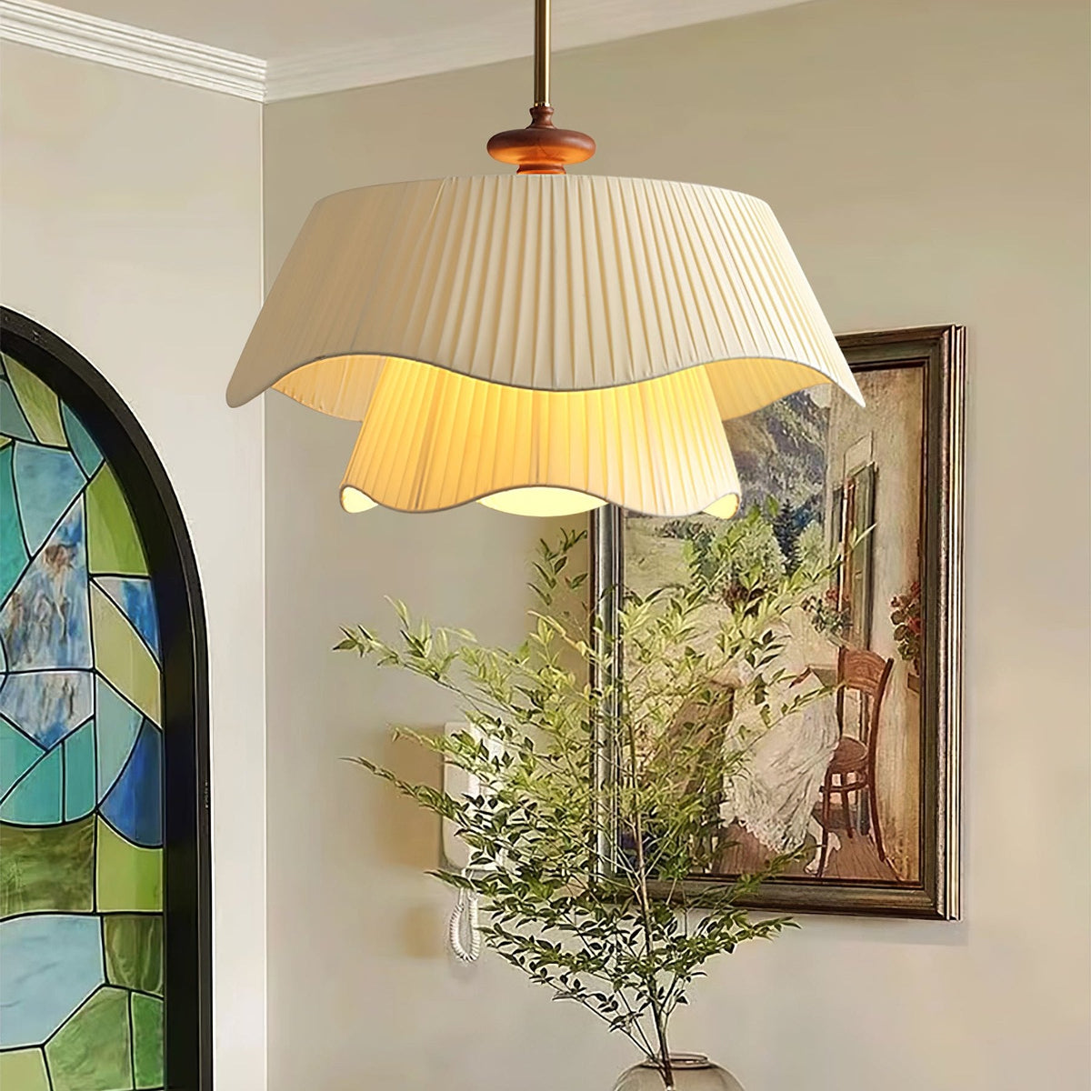 Warm light spills from the lower layer of this Clérachic pendant, set in a hallway with a stained-glass arch and a framed painting.
