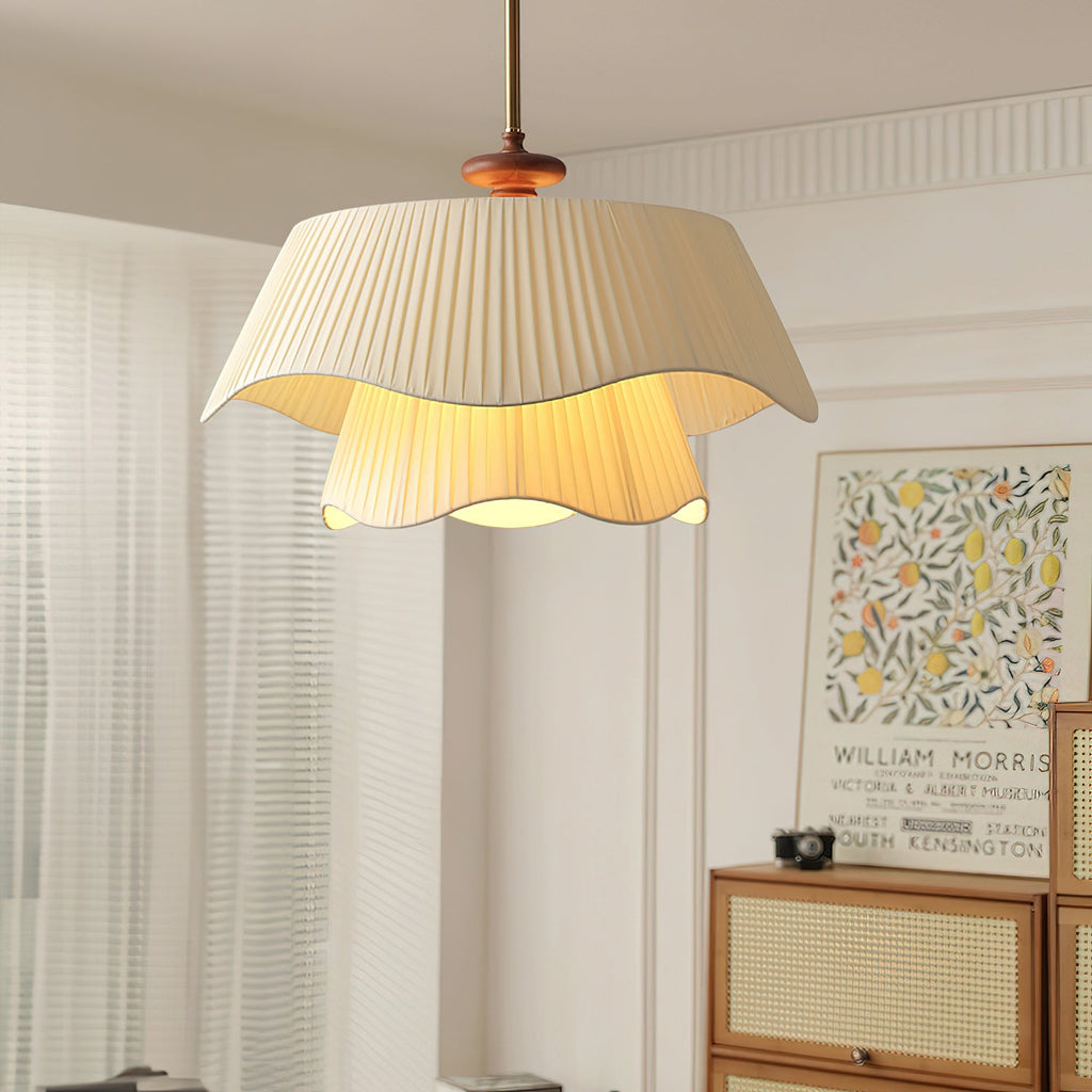 Clérachic pendant seen from below in a bright room, with sheer curtains, a rattan cabinet and a framed fruit print behind.