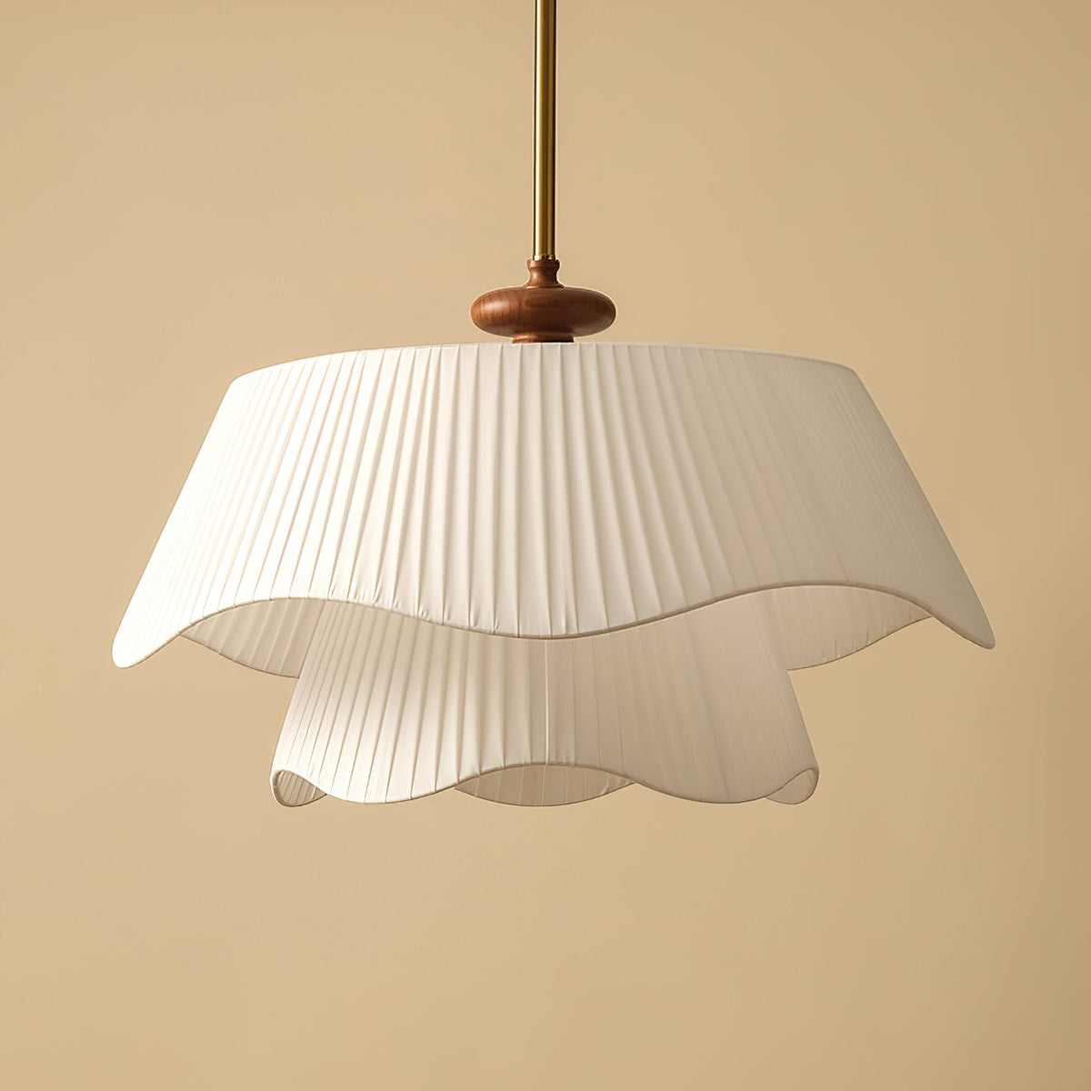 Close view of the pleated fabric folds and wavy hem on this Clérachic pendant, with its dark wooden bead and gold stem.