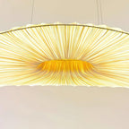 Close view of the pleated ribs and the golden centre of this Clérachic pendant shade, with the cables above.