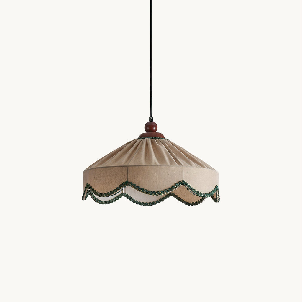 Clérachic pendant with a pleated beige shade, green scalloped trim and a walnut-brown cap, hung on a black cord against white.