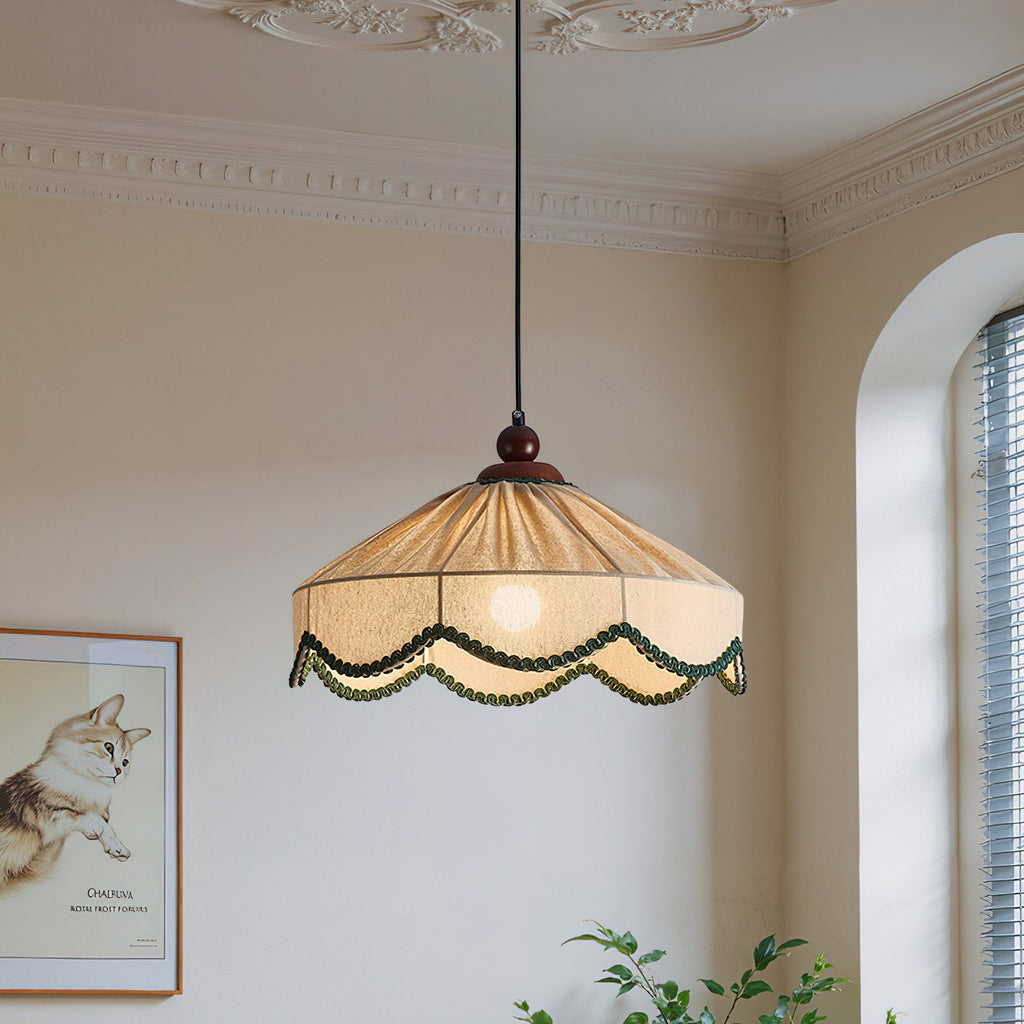 Lit Clérachic pendant with a pleated shade in a room with an arched window, a cornice and a framed cat print.