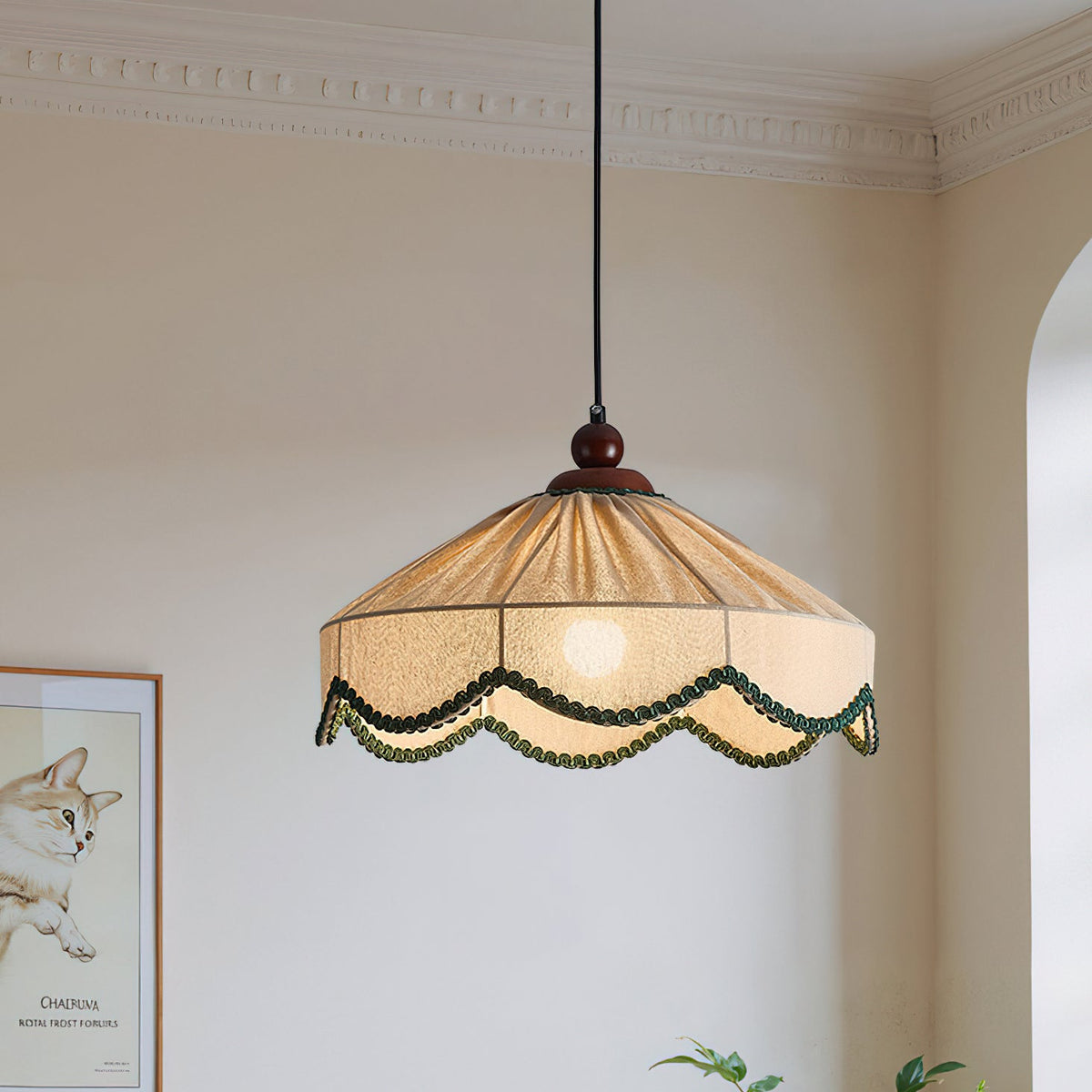 Clérachic pleated beige pendant hung close to the camera, its green scallops bright, with an arched window behind.