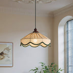 Clérachic pleated beige pendant seen from slightly farther back, with a cat print, green plants and an arched window.