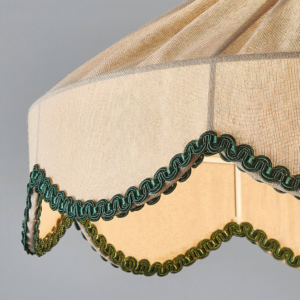 Close view of the scalloped green braid and pleats on the lit shade of this Clérachic pendant.