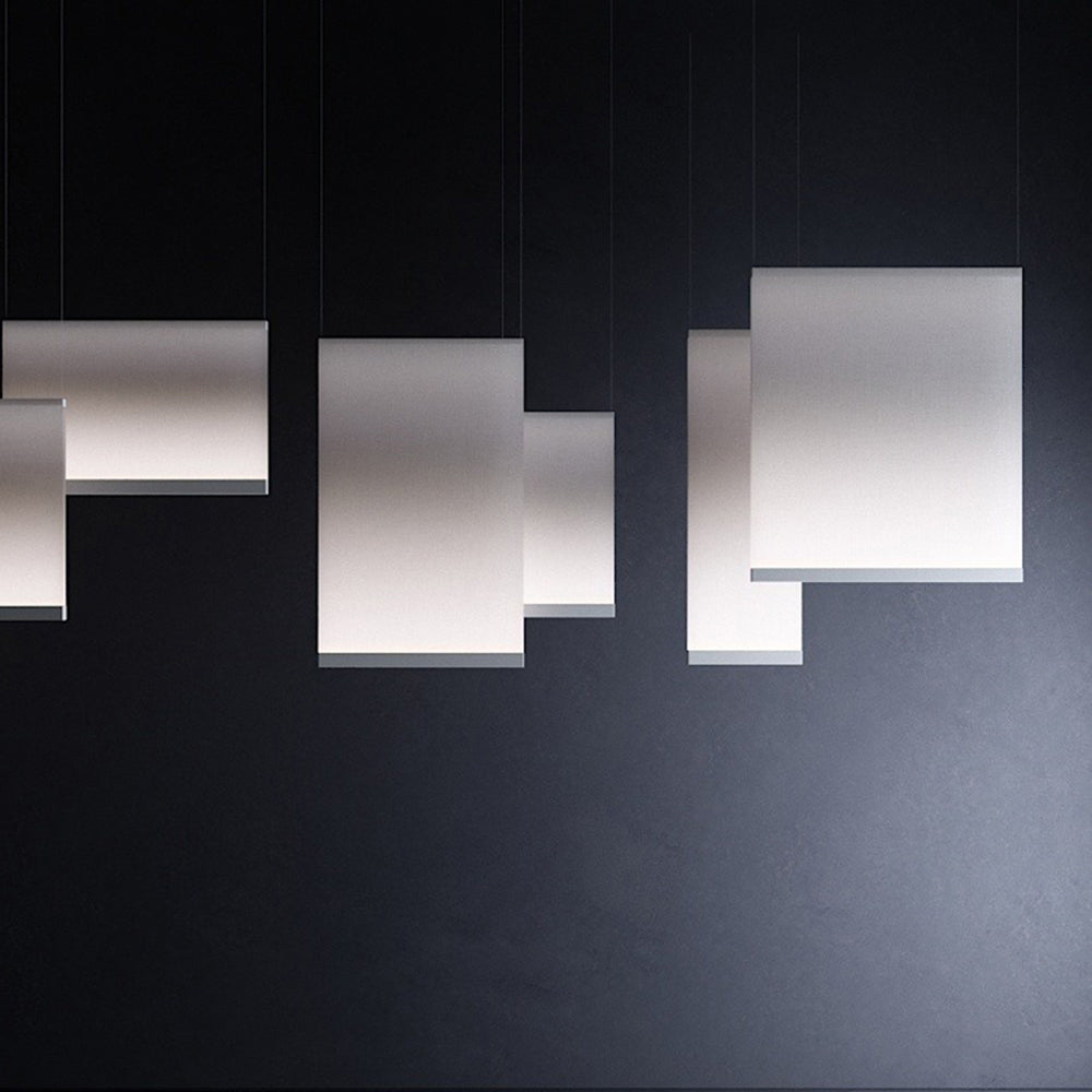 Cluster of Clérachic fabric pendants of different sizes against a dark navy backdrop, their lower edges softly lit.