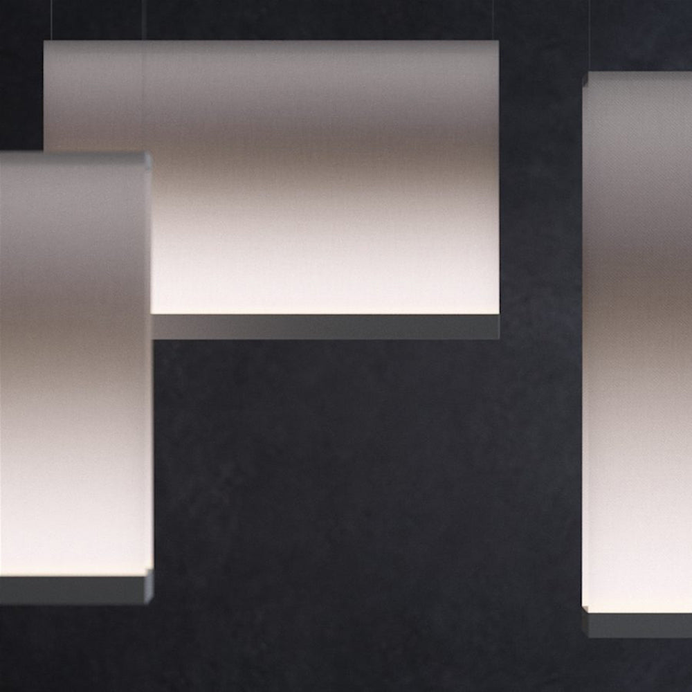 Close view of overlapping Clérachic fabric pendants with dark lower bars, set against a dark textured backdrop.