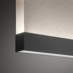 Close view of the black bottom bar on this Clérachic fabric pendant, with a diagonal woven fabric above it and a light line below.