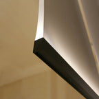 Close view of a Clérachic fabric panel curling above a black bar, with warm light along its edge against a wooden wall.