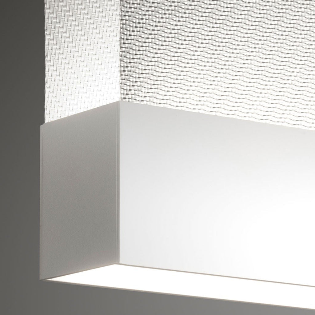 Close view of a white bottom bar on this Clérachic fabric pendant, with a fine woven fabric above it and a bright light line below.