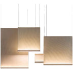 Several Clérachic fabric pendants of different sizes lit in warm tones, hung at staggered heights on thin wires against white.