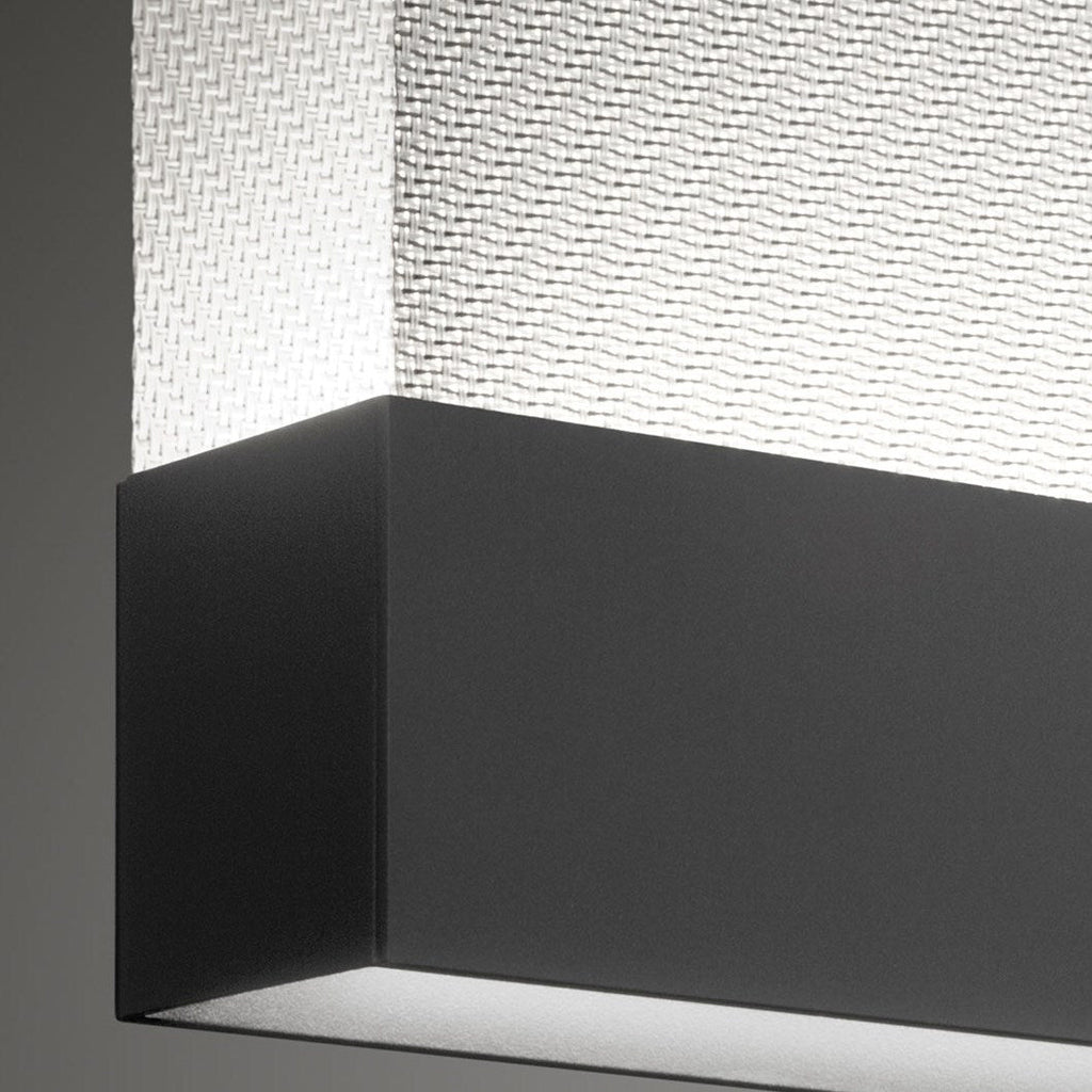 Close view of the black bottom bar and woven fabric on this Clérachic pendant, with a light line along the underside.