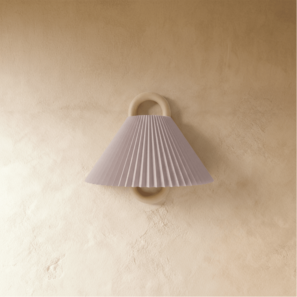 Clérachic wall light with a pleated blush pink fabric shade on a wood ring mount, unlit against a warm plaster wall.