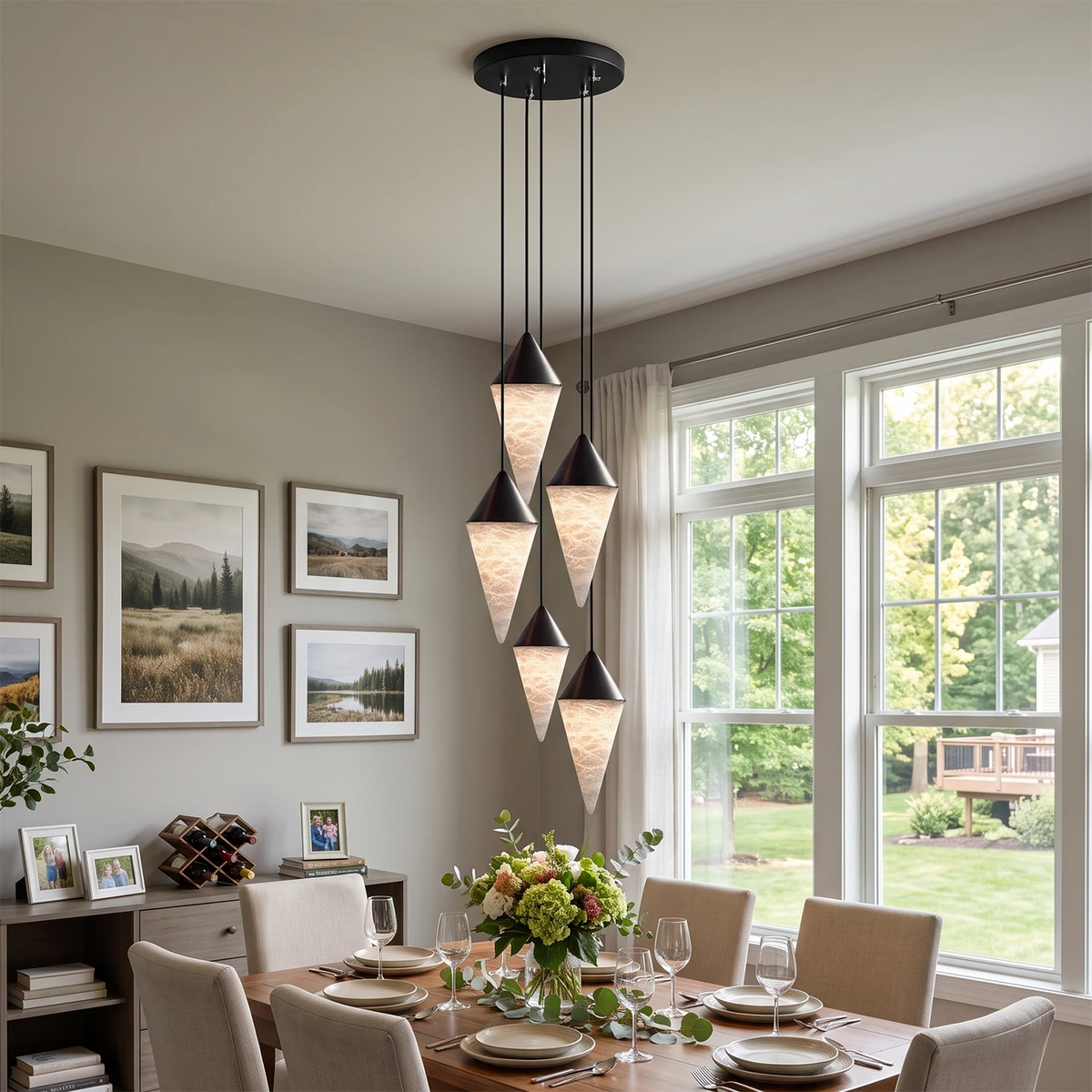 A gallery wall of framed art lines the room where this Clérachic chandelier's black-capped drops cluster overhead.