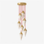 A soft grey background sets off this Clérachic chandelier's spiral of brass-capped drops on red cords.