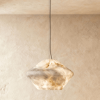 Clérachic alabaster pendant with a faceted double-cone shade of veined cream stone, glowing warm on a slim cable.