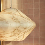 Close detail of the Clérachic alabaster pendant, with brown marble-like veining across its warm cream stone shade.