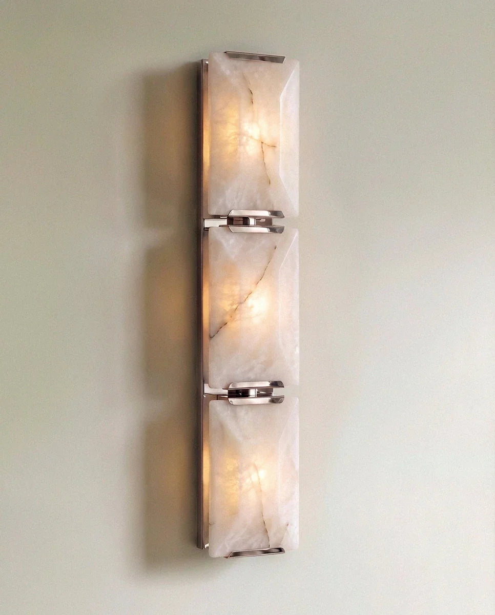 Clérachic three-panel alabaster wall light in polished steel, lit, three glowing stone panels joined by bright clips