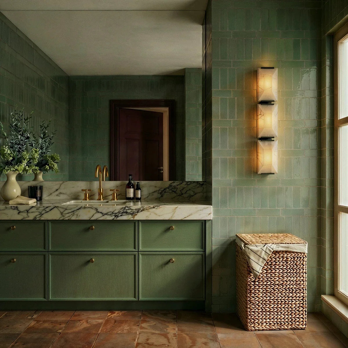 Clérachic three-panel alabaster wall light beside a window on green tiles, opposite a mirror and a sage-green vanity