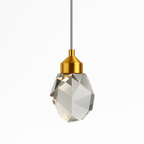 Clérachic single faceted crystal pendant light with a brushed gold cap and grey cord, unlit on a clean white ground.