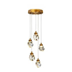 Clérachic five-head round crystal pendant light with faceted drops at staggered heights below a gold circular canopy.