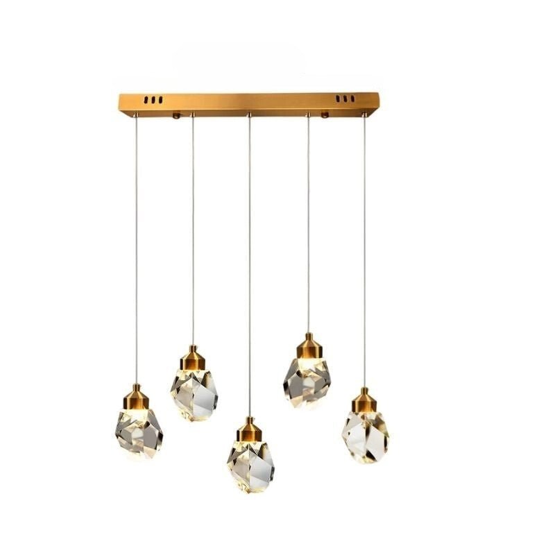 Clérachic five-head linear crystal pendant light with faceted drops at staggered heights below a long gold bar canopy.