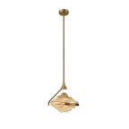 A full-length amber glass pendant hangs from a small gold ceiling plate on a slim gold rod against white, from Clérachic.