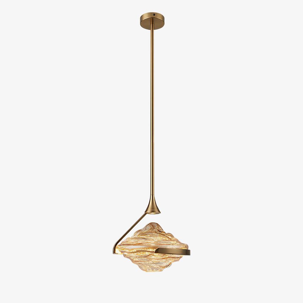 A faceted amber glass pendant hangs from a small gold ceiling plate on a slim rod against a pale grey backdrop, from Clérachic.