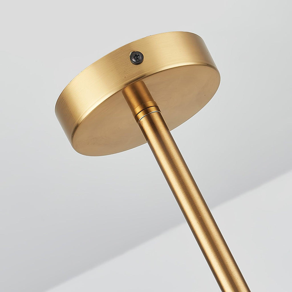 Close view of the round brushed gold ceiling plate and the slim gold rod of this Clérachic pendant, from below.