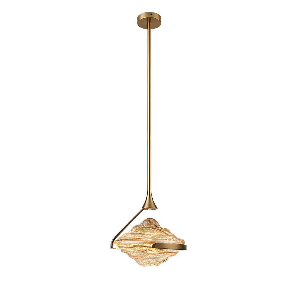 A faceted amber glass pendant on a gold rod and ceiling plate hangs against a plain white backdrop, a Clérachic pendant.