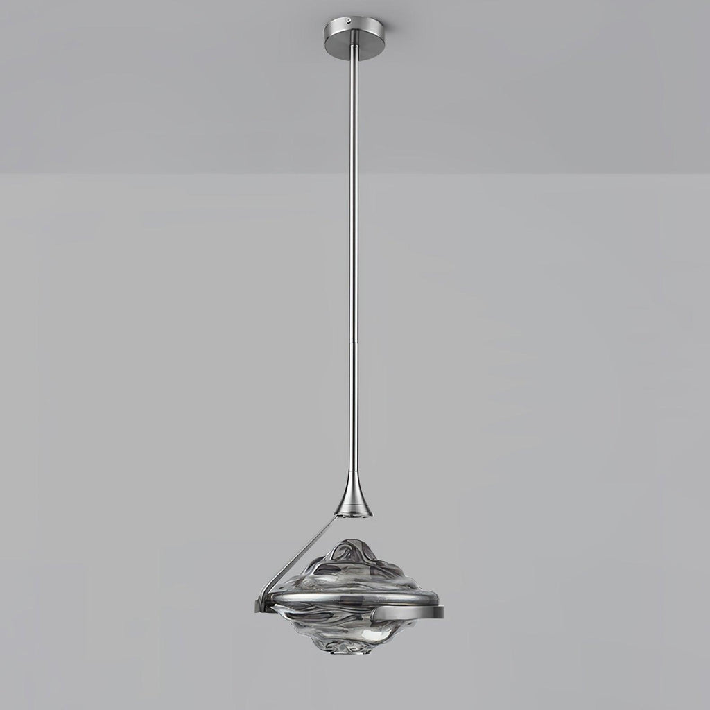 A faceted smoke grey glass pendant on a chrome rod and ceiling plate hangs against a grey backdrop, from Clérachic.